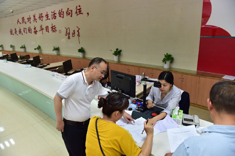 南岭村社区党委书记,居委会主任张育彪(左一)在社区党群服务中心