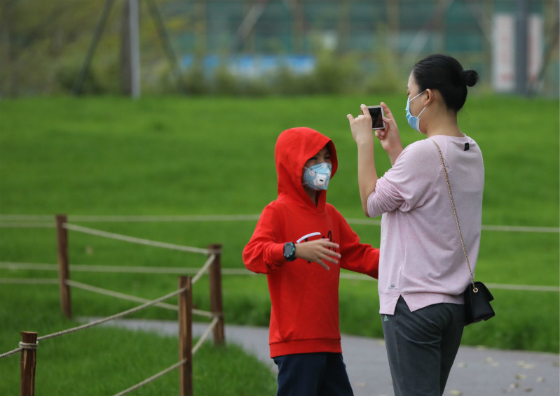 一位妈妈正在给儿子拍照留念享受平静生活